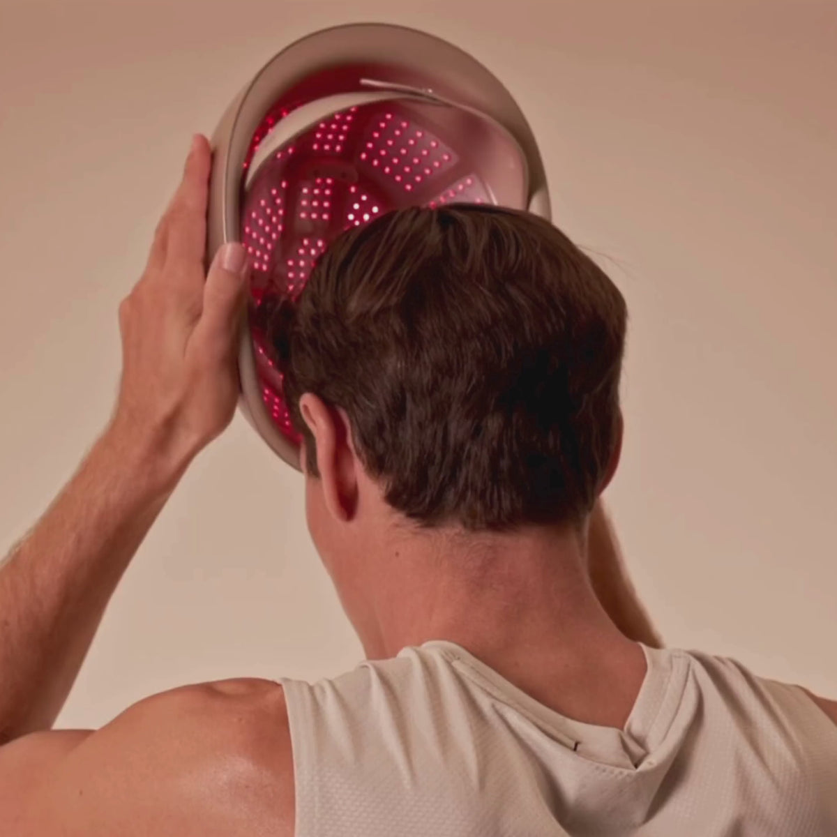 Video: man putting on the LumaLase laser hair growth helmet and adjusting the fit, then a woman wearing it